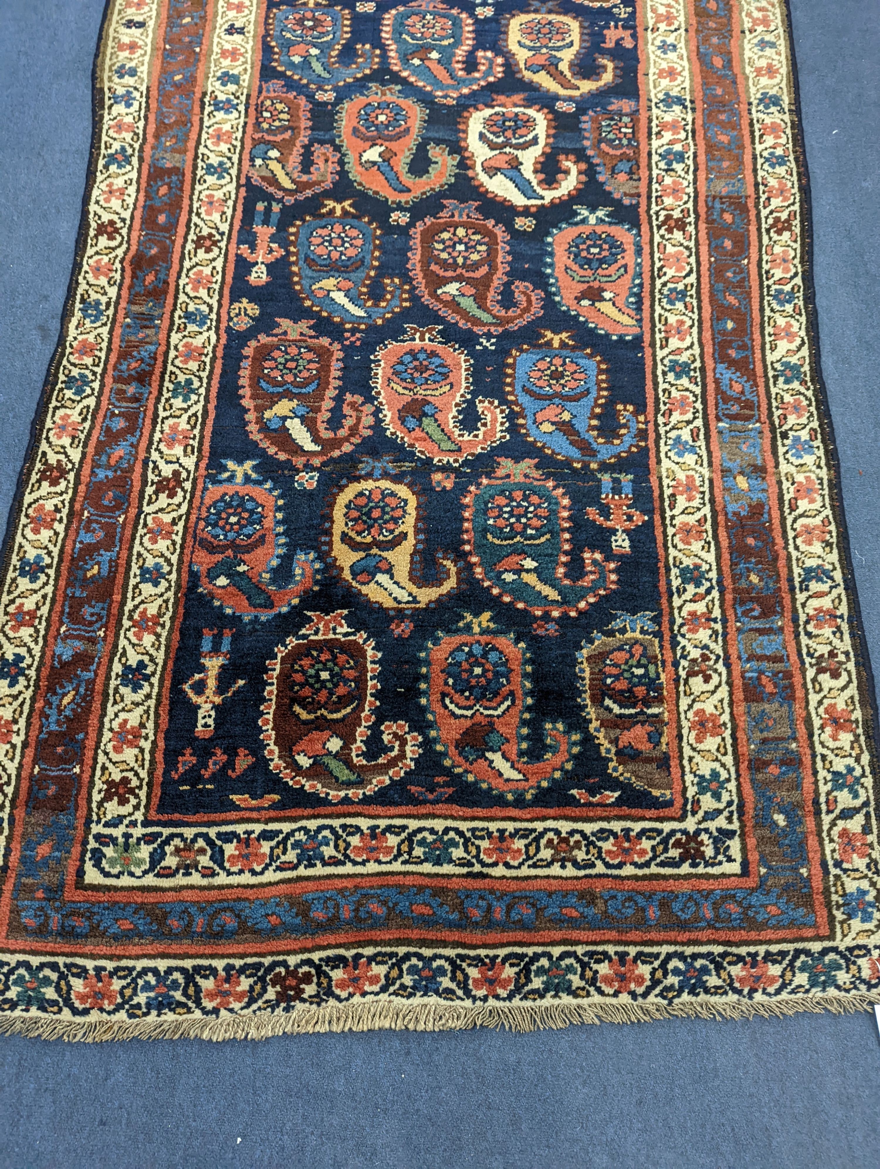 A Caucasian Karabagh blue ground runner, woven with rows of stylised boteh, figures and birds, 477 x 117cm